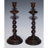 A pair of oak open-twist table candlesticks, campana sconces, dished drip pans, turned bases, 34.5cm