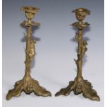 A pair of French gilt bronze candlesticks, cast with fruiting oak, each with a squirrel scaling