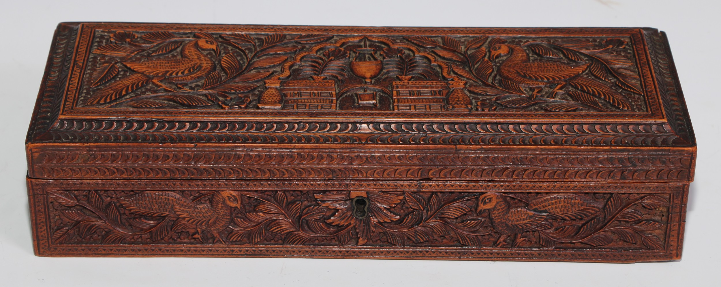 An Indian sandalwood rectangular box, hinged cover, carved in relief with peacocks, architecture,