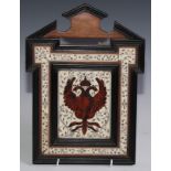 A North Italian walnut, ebonised tortoiseshell and engraved bone marquetry armorial panel, inlaid in