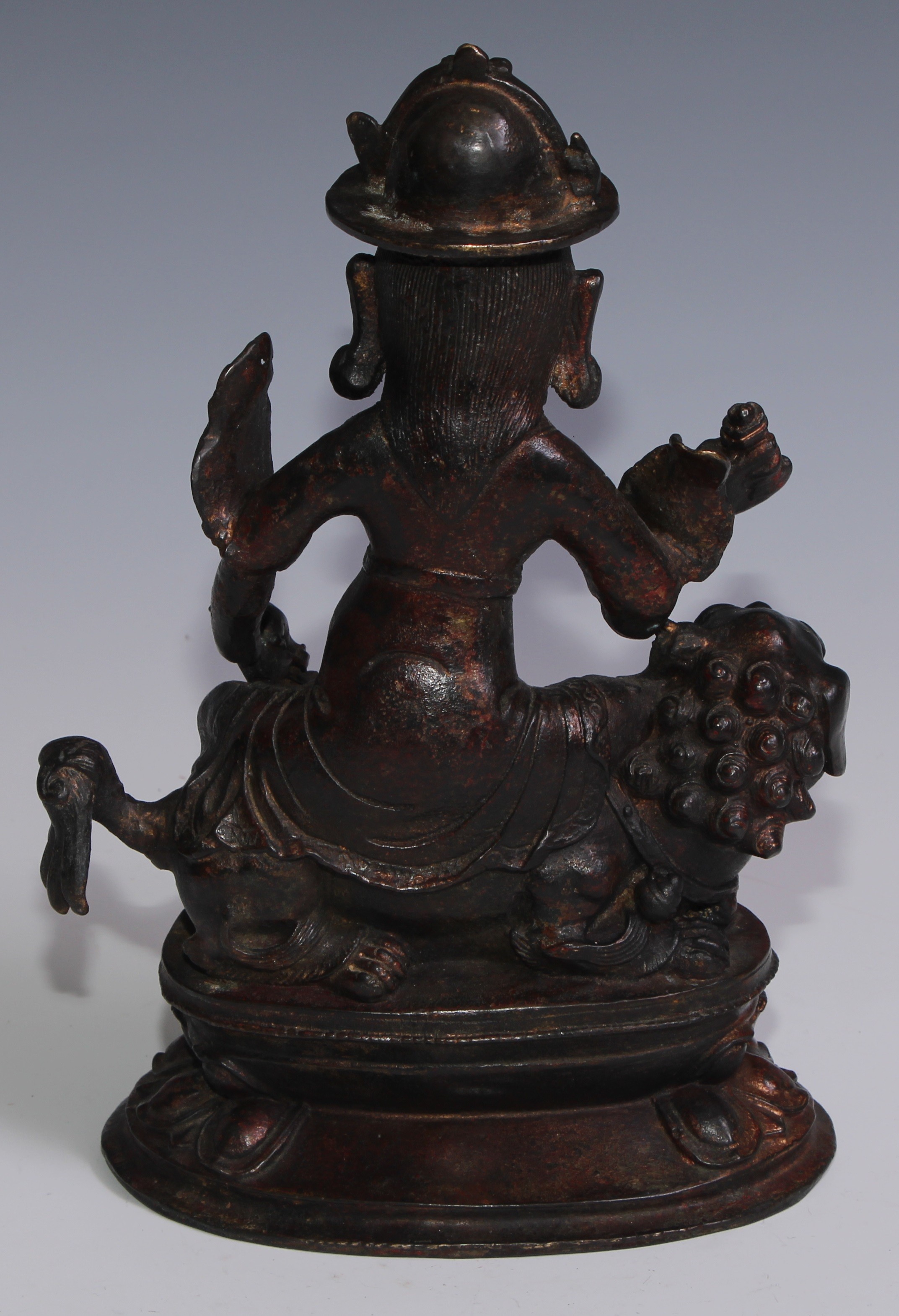 Tibetan School, a red and gilt patinated bronze, Vajrasadhu seated on a lion, lotus base, 28cm high - Image 4 of 4