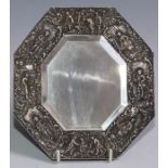 A 19th century electrotype octagonal looking glass, the border in relief with Rococo genre scenes,