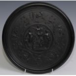 A 19th century bois durci roundel, in relief with after T Canu with an allegory of science and