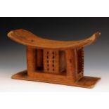 Tribal Art - an Ashanti stool, dished seat, curved legs, centred by a reticulated square column,