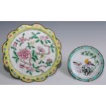 A Cantonese enamel shaped circular plate, painted in the famille rose palette with flowering