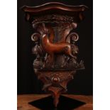 A 19th century Continental walnut wall bracket, carved with a stag above a hunting trophy,