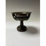 A 19th century bronze two handled shallow campana shaped mantle urn, the angular loop handles