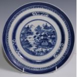 A Chinese circular plate, painted in tones of underglaze blue with a figure on a bridge, in a