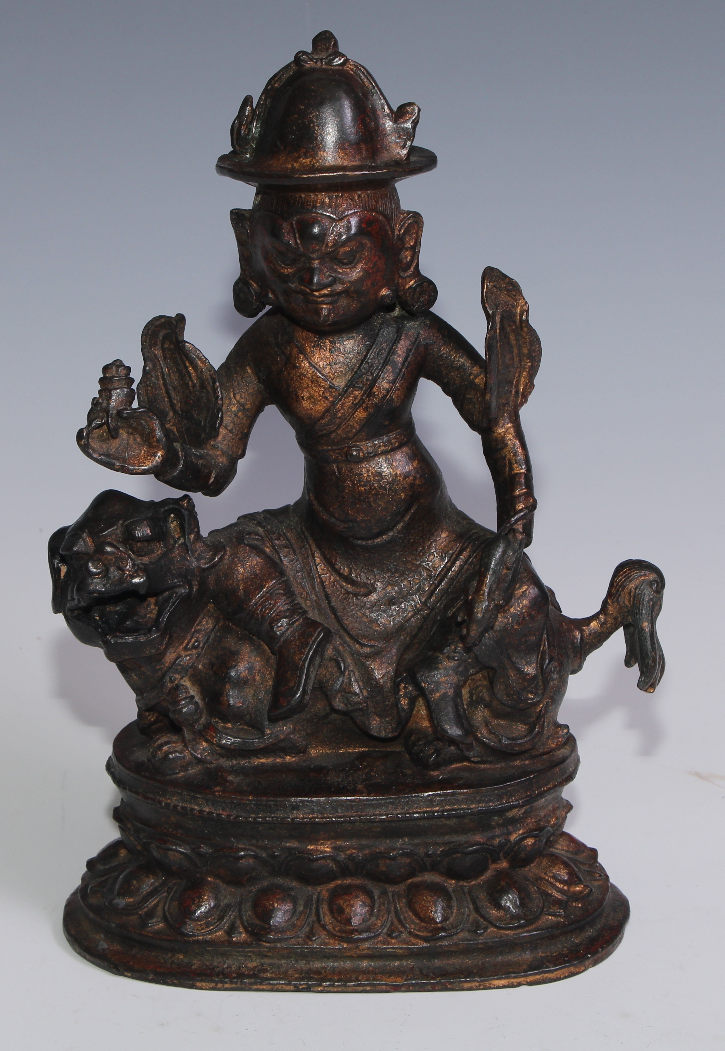 Tibetan School, a red and gilt patinated bronze, Vajrasadhu seated on a lion, lotus base, 28cm high