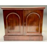 A Victorian mahogany table top collector's cabinet, oversailing top above a pair of arched