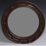 A 19th century oak convex looking glass, plain mirror plate, the border applied with a band of