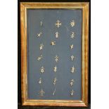 A collection of Tuareg silvered agadez crosses, various forms, Niger, framed, the arrangement 48cm x