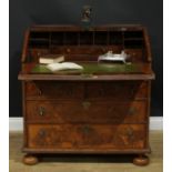 An 18th century featherbanded walnut bureau, fall front with reading ledge enclosing a tooled and