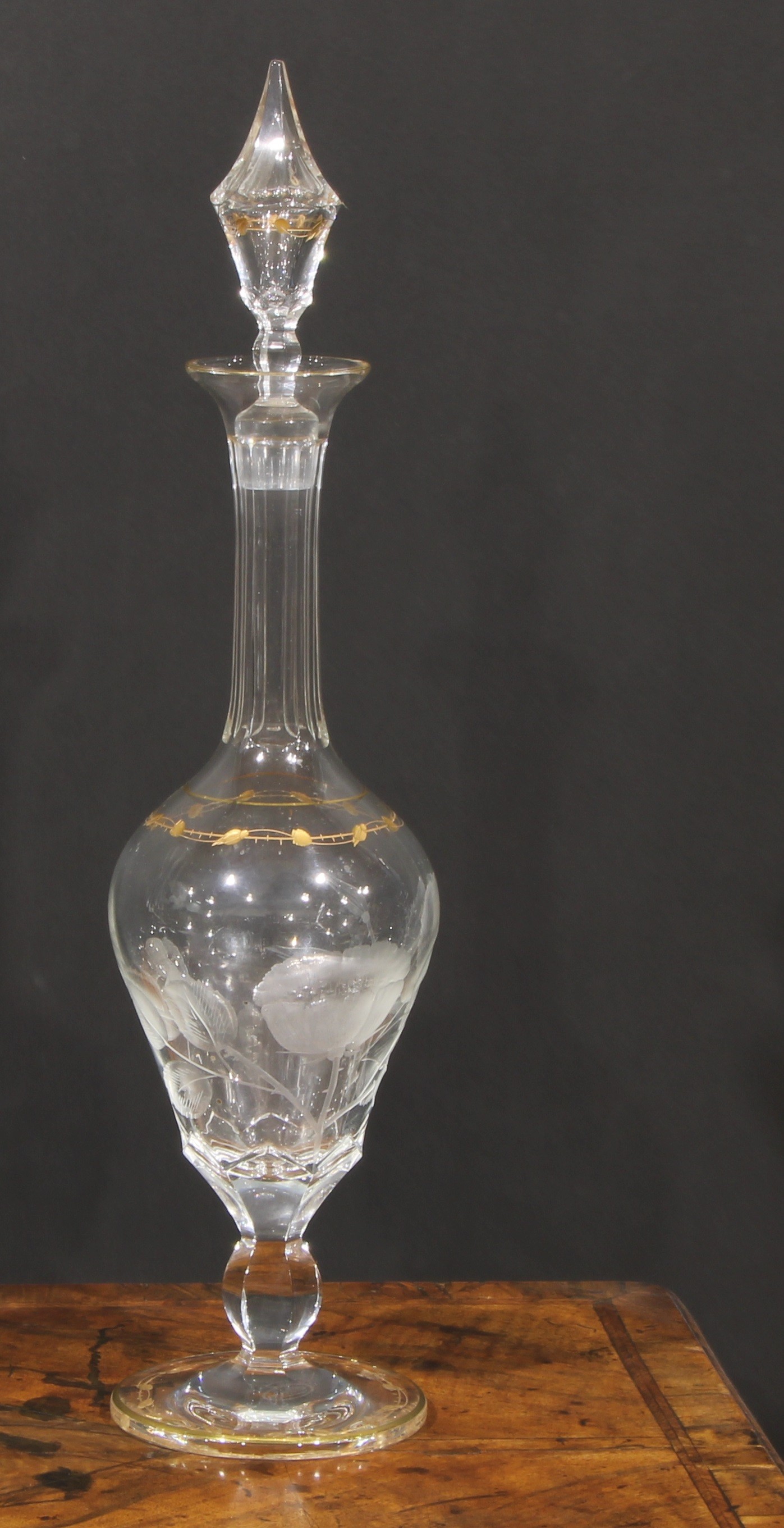 A large late 19th century ovoid pedestal decanter, etched with poppies and gilt with bands of