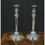 A pair of Continental silver circular table candlesticks, chased and applied with fruiting vine