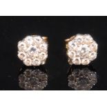 A pair of diamond flower head cluster ear studs, stamped '750' for 18ct gold, set with nine round