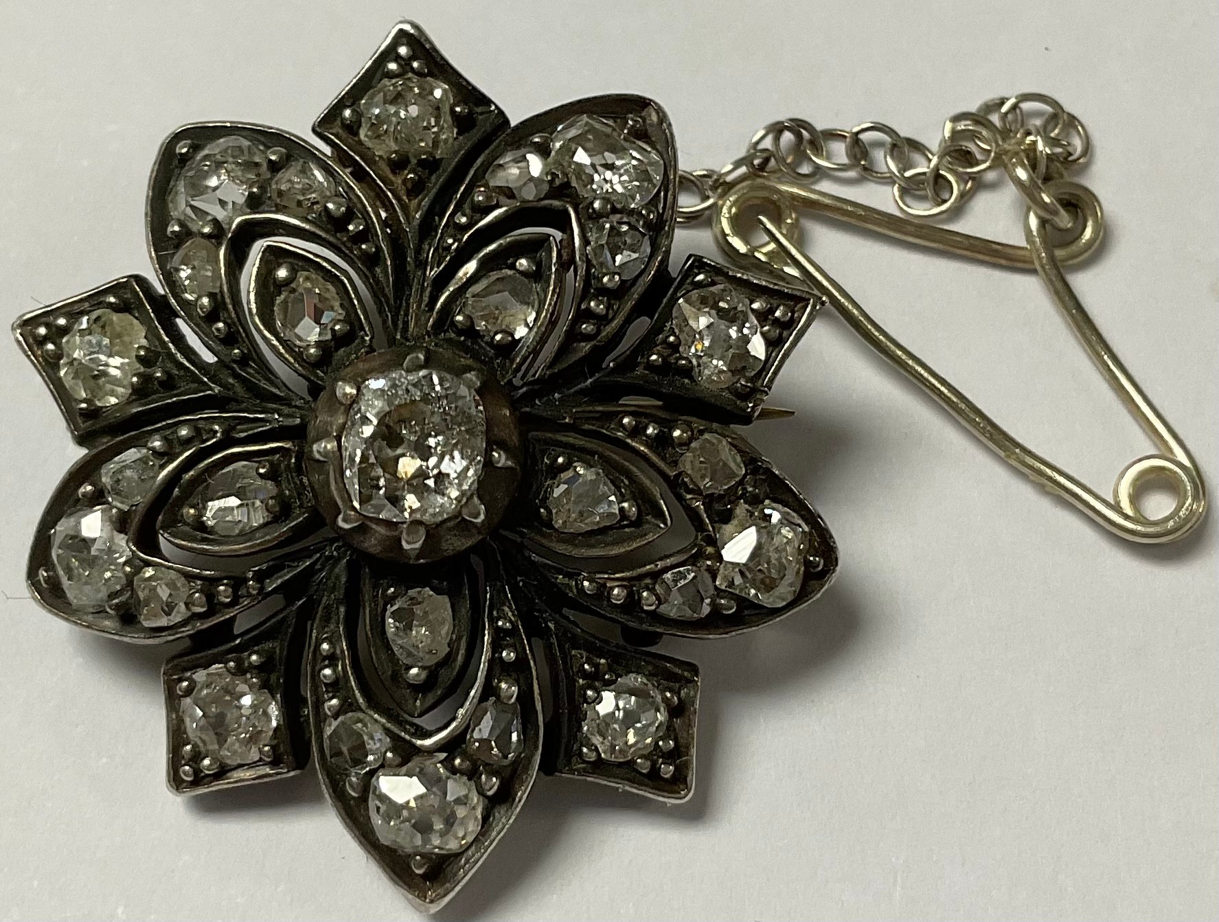 A Victorian diamond flowerhead brooch, the five petals divided by pointed panels, the whole set with - Image 3 of 3