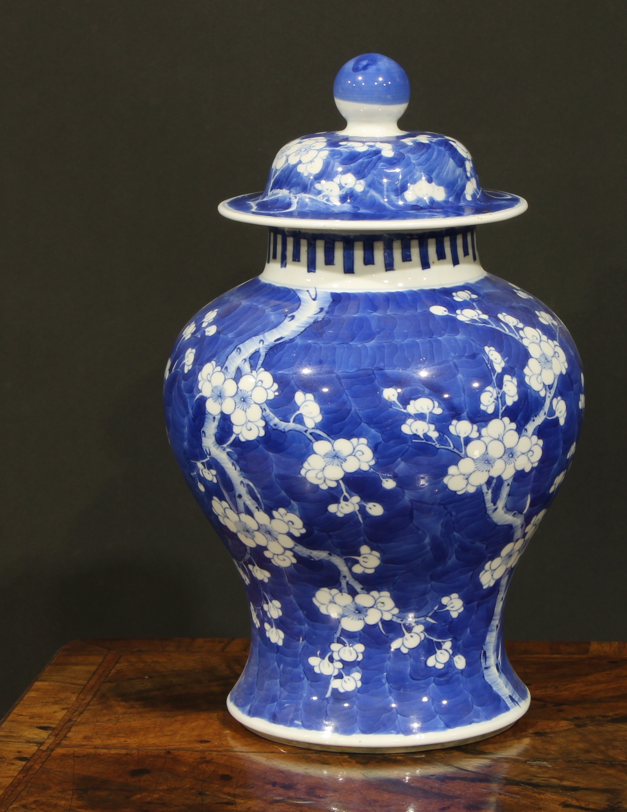 A Chinese baluster jar and cover, painted in tones of underglaze blue with blossoming prunus on a