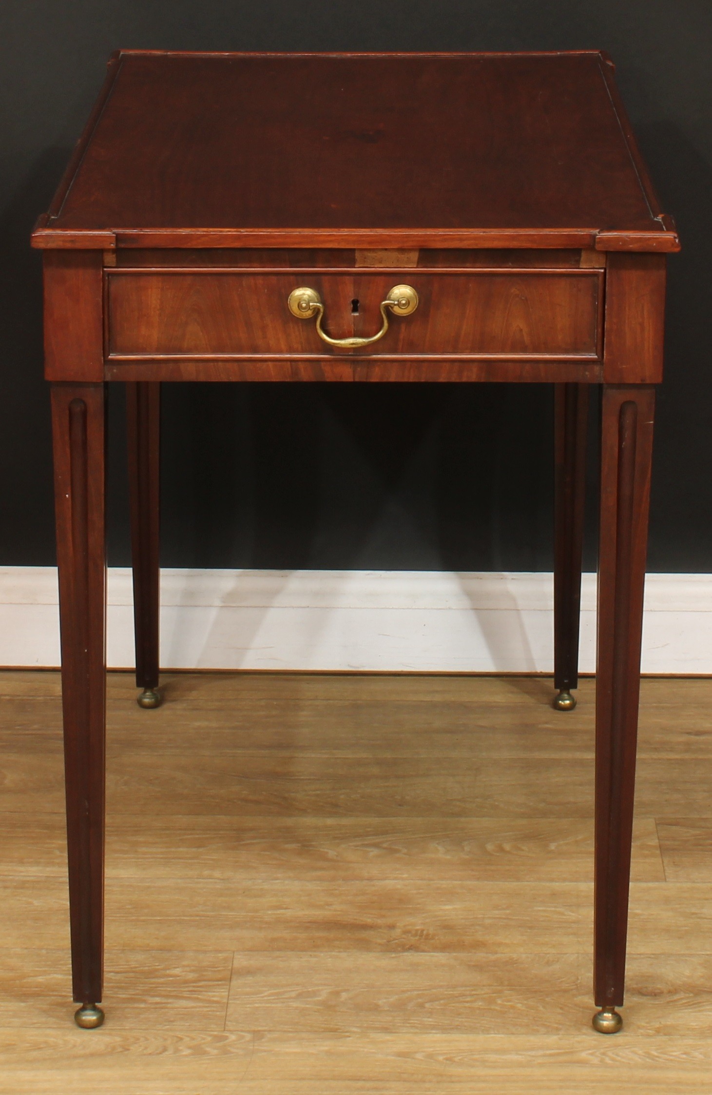 A George III mahogany silver table, angular hipped rectangular top above a cockbeaded frieze drawer,