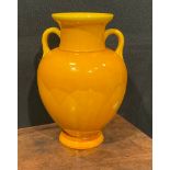 A Burmantofts Faience two handled amphora shaped vase, glazed throughout in yellow, 23cm high, shape