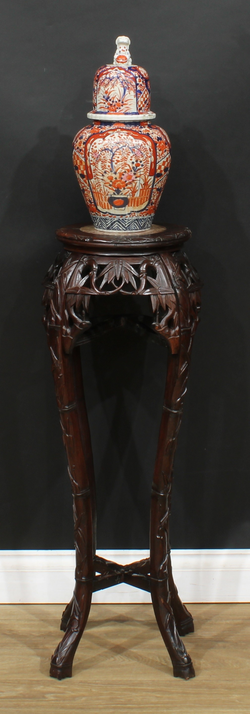 A Chinese hardwood jardiniere stand, circular top with inset soapstone panel, above a shaped