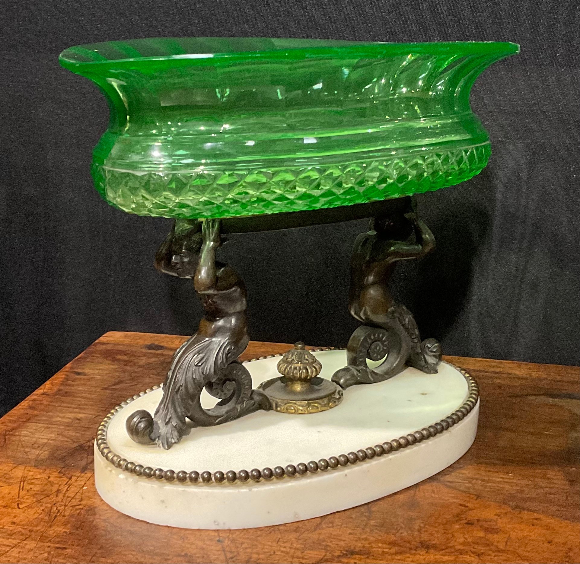 A 19th century dark patinated bronze, carara marble and green glass table centrepiece, the oval