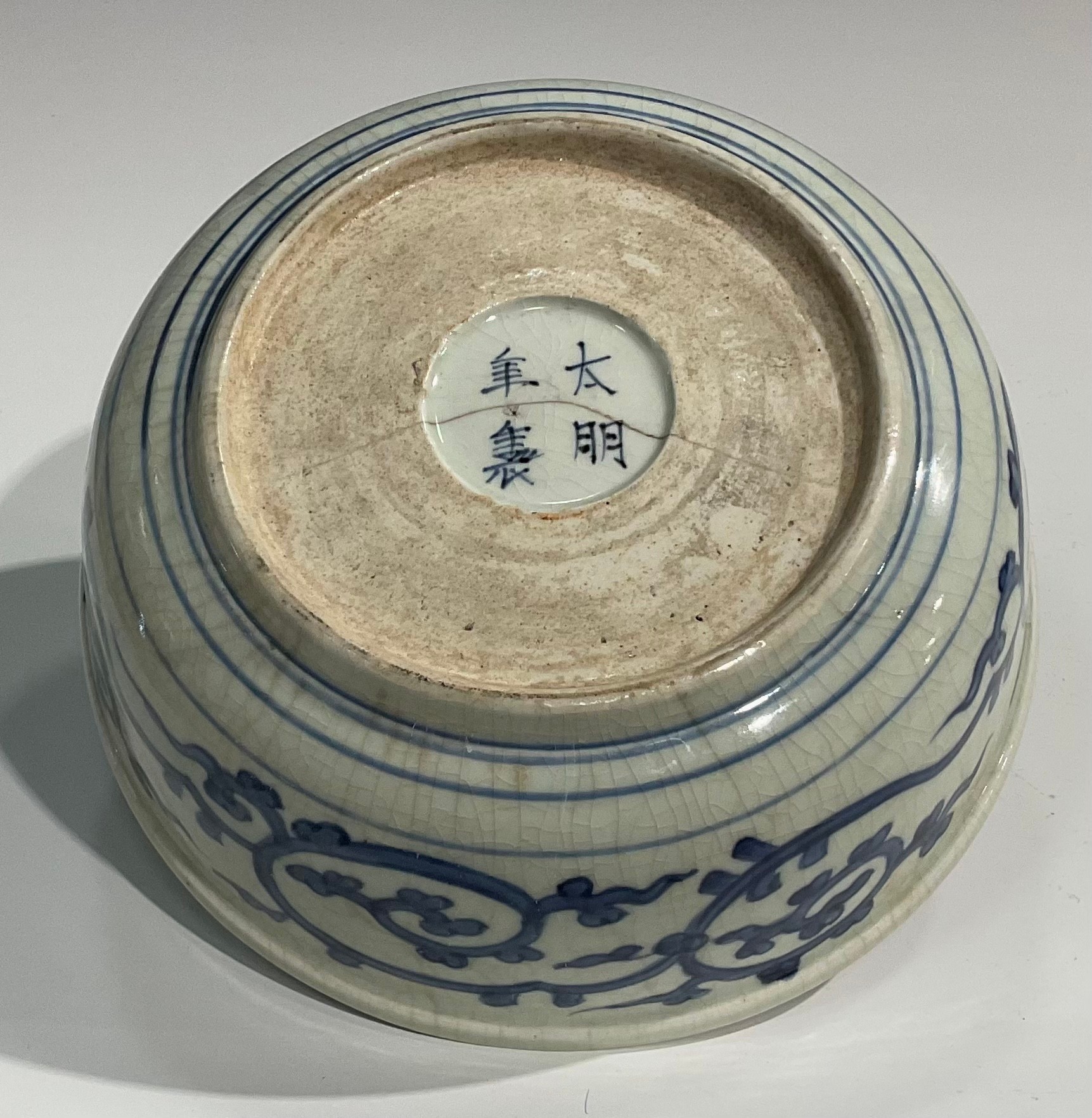 A Chinese circular bowl, painted in tones of underglaze blue with prunus, chrysanthemums and - Image 5 of 5