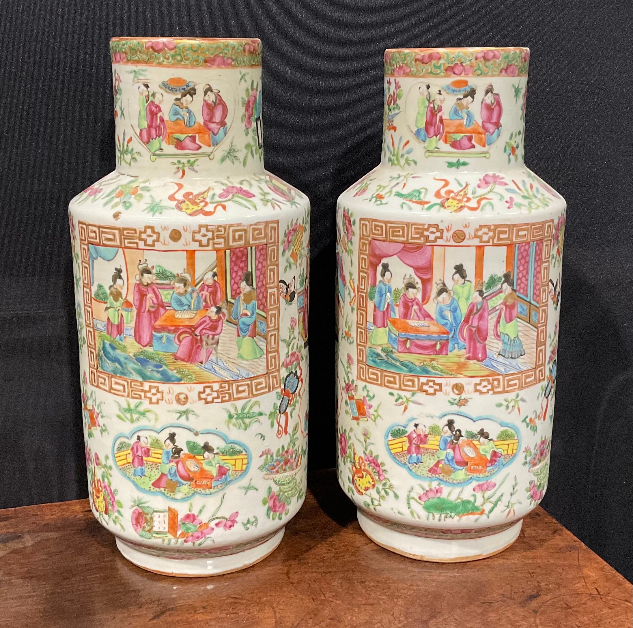 A pair of Cantonese Famille Rose cylindrical vases, decorated with alternating shaped panels of