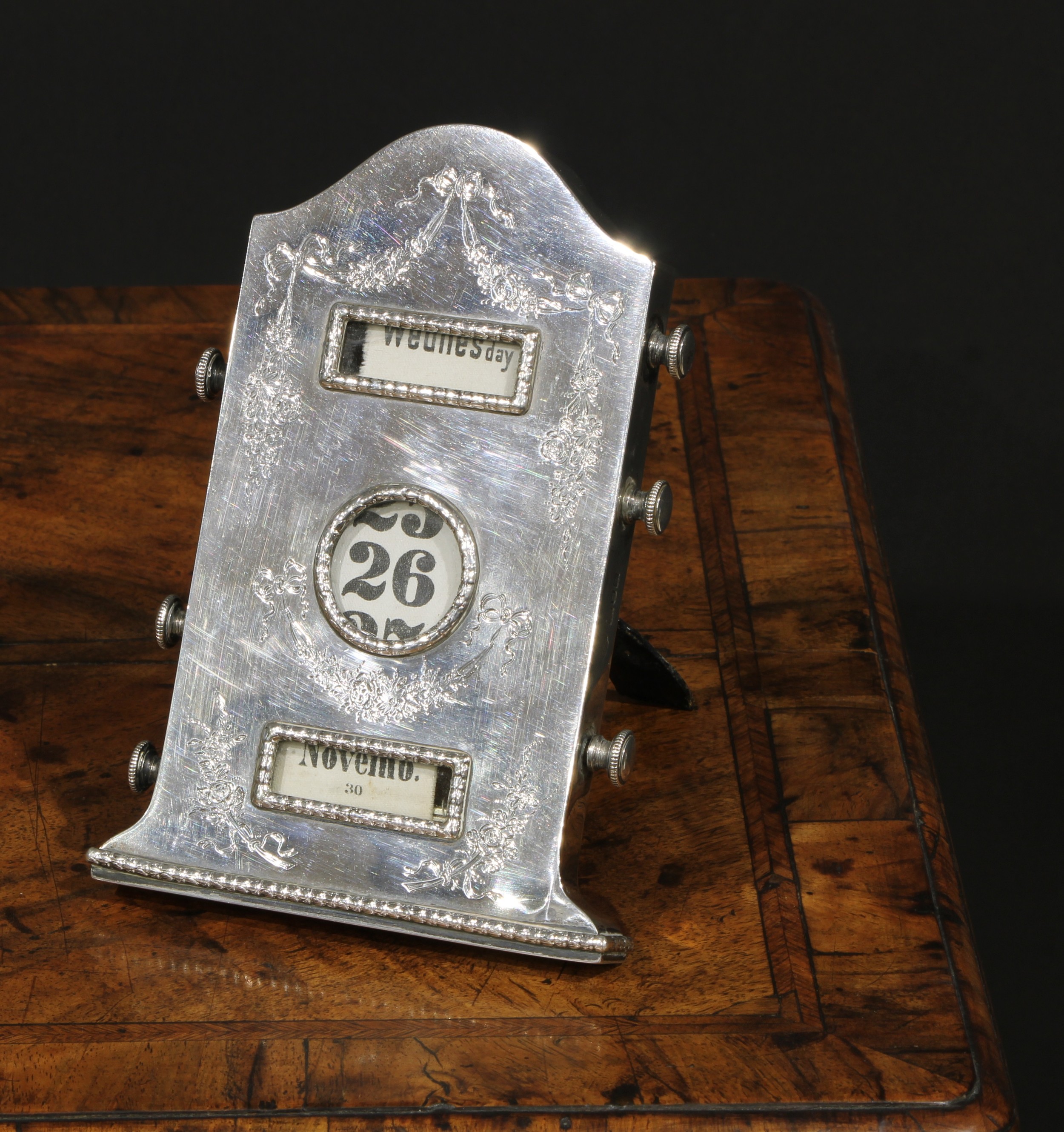 An Edwardian silver arched rectangular easel perpetual desk calendar, engraved in the Neo-