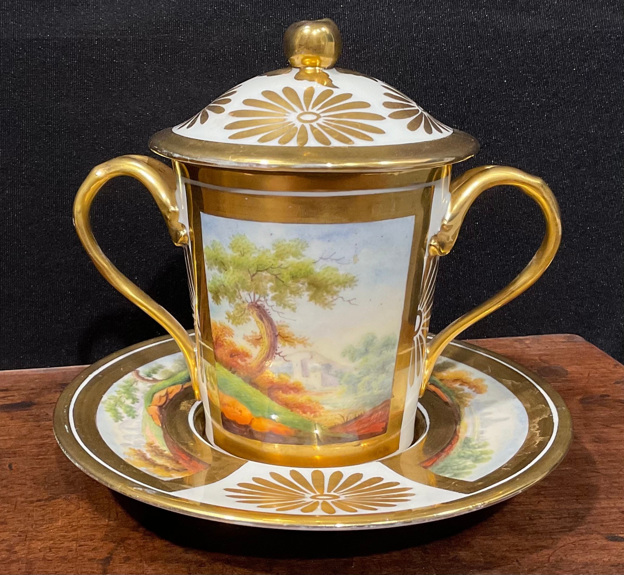 A 19th century Paris porcelain two handled covered chocolate cup and stand, the cup and saucer