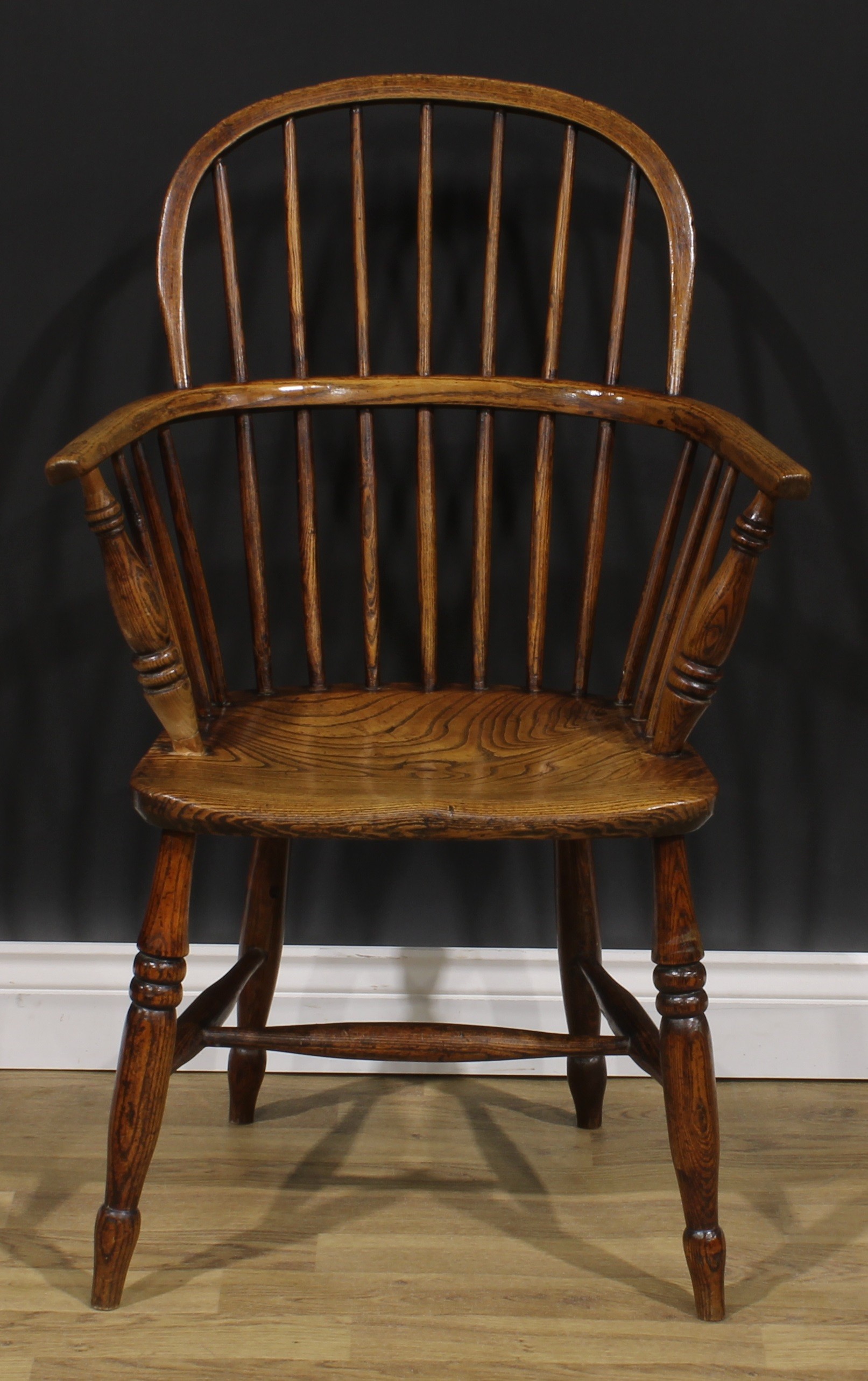 A 19th century ash and elm Windsor elbow chair, low hoop back, saddle seat, H-stretcher, 95cm