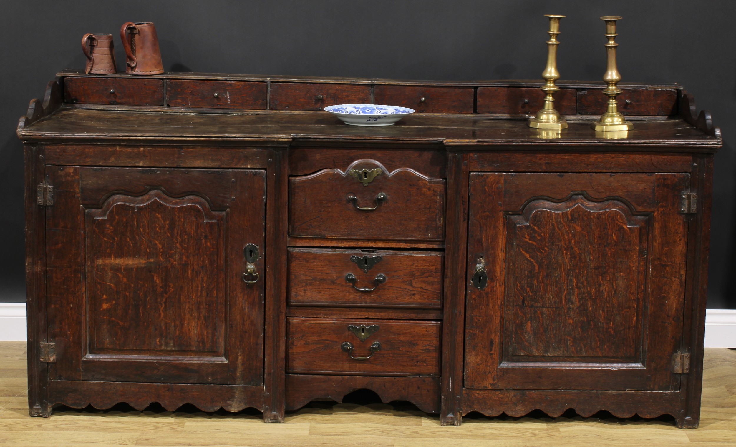 An 18th century oak low dresser, rectangular top with six small drawers above a pair of raised and