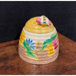 A Clarice Cliff Bizarre Fantasque Petunia pattern ribbed domed honey pot and cover, painted with