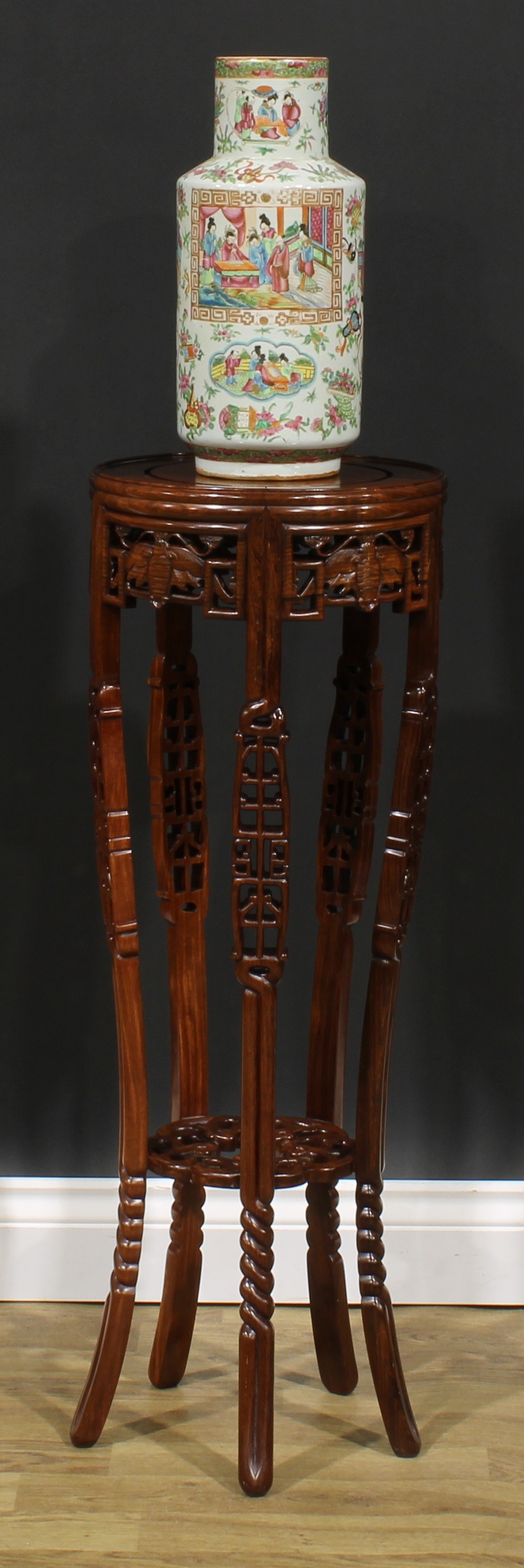 A Chinese hardwood jardiniere stand, circular top, shaped apron pierced and carved with moths,