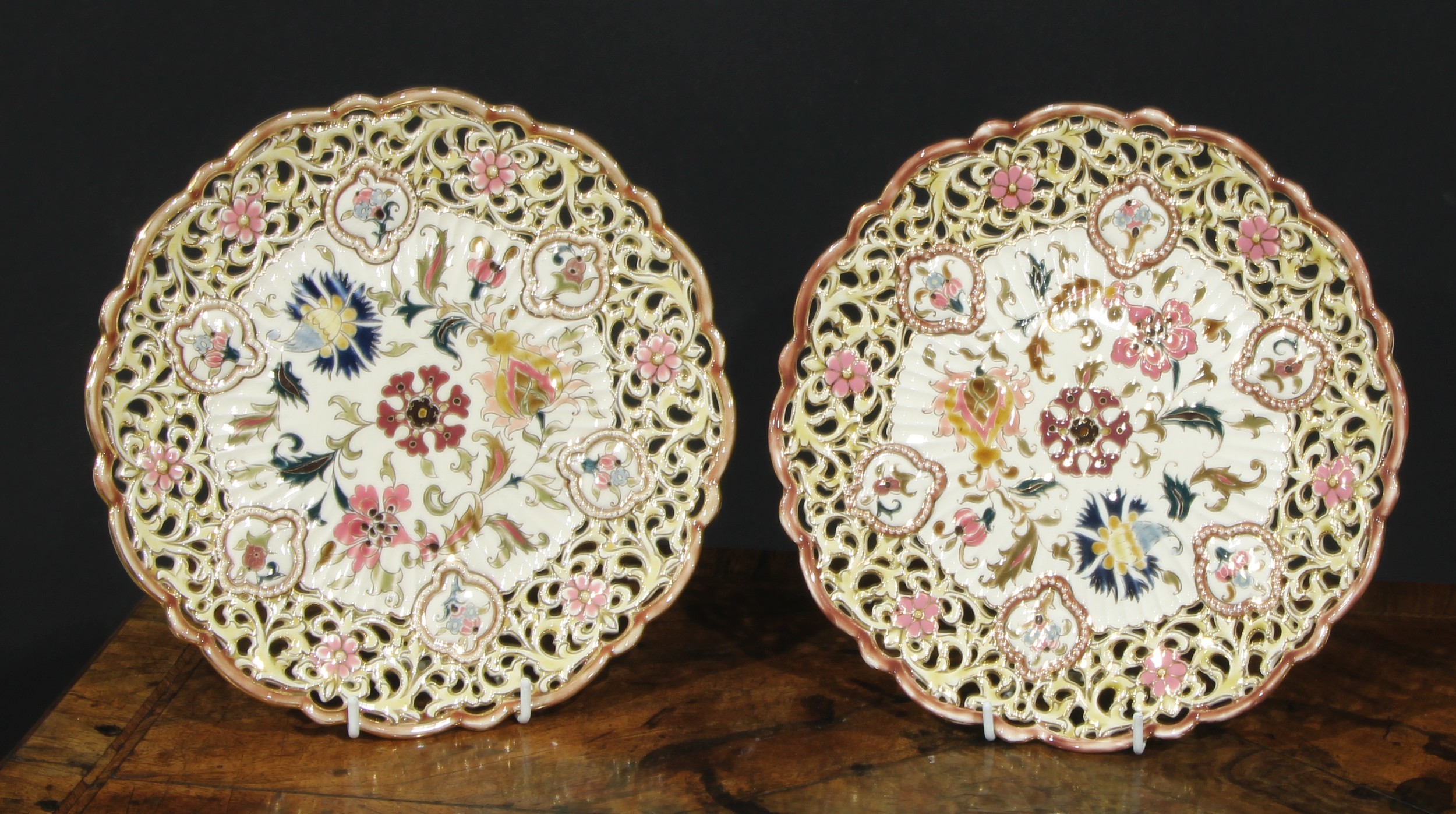 A pair of Zsolnay Pecs shaped circular plates, each decorated in polychrome with stylised flowers,