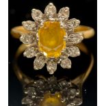 A diamond, yellow sapphire and 18ct gold cluster ring, central oval raised claw set stone within