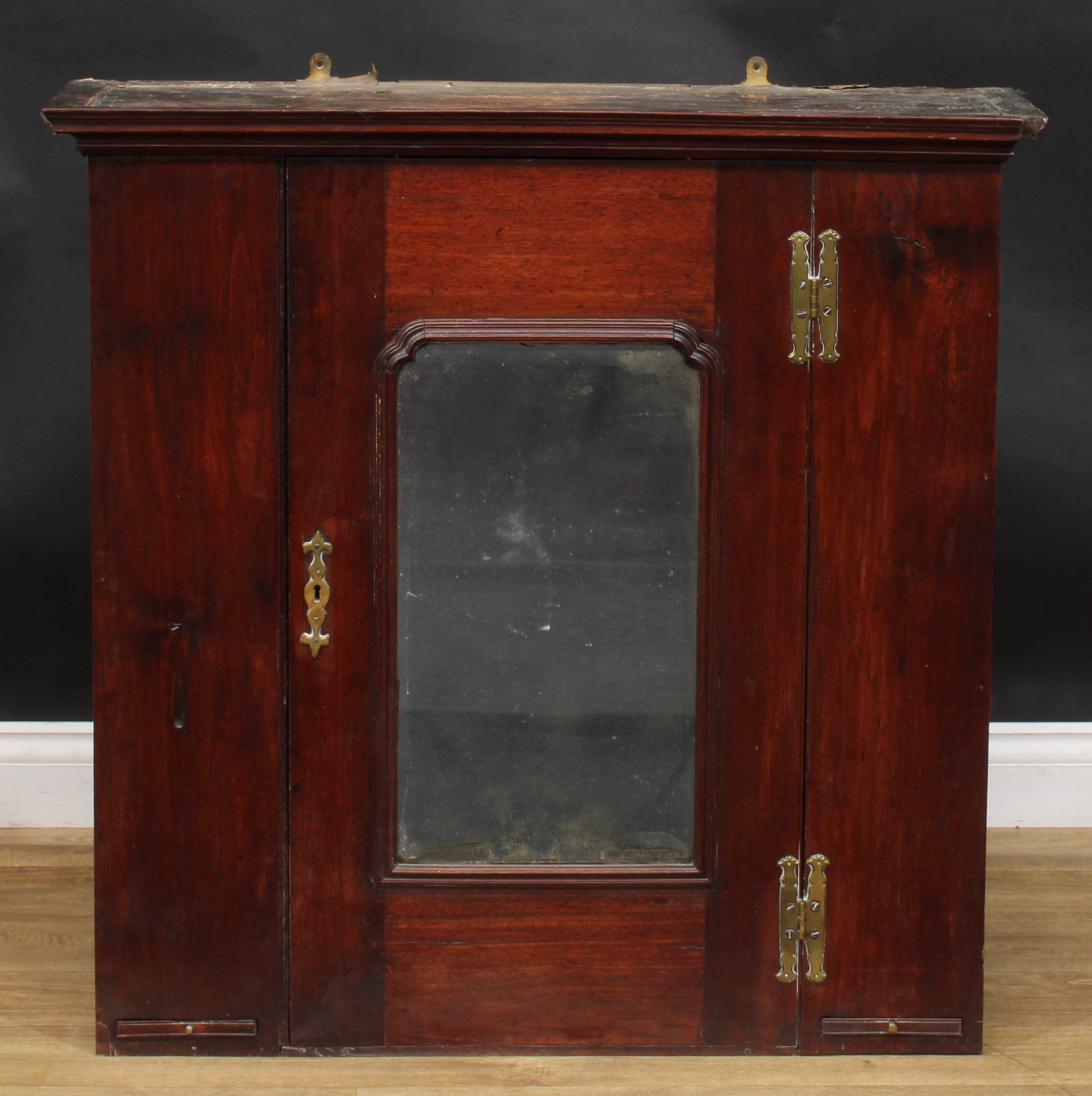 A George III mahogany wall-hanging provision cupboard, moulded cornice above a rectangular door with