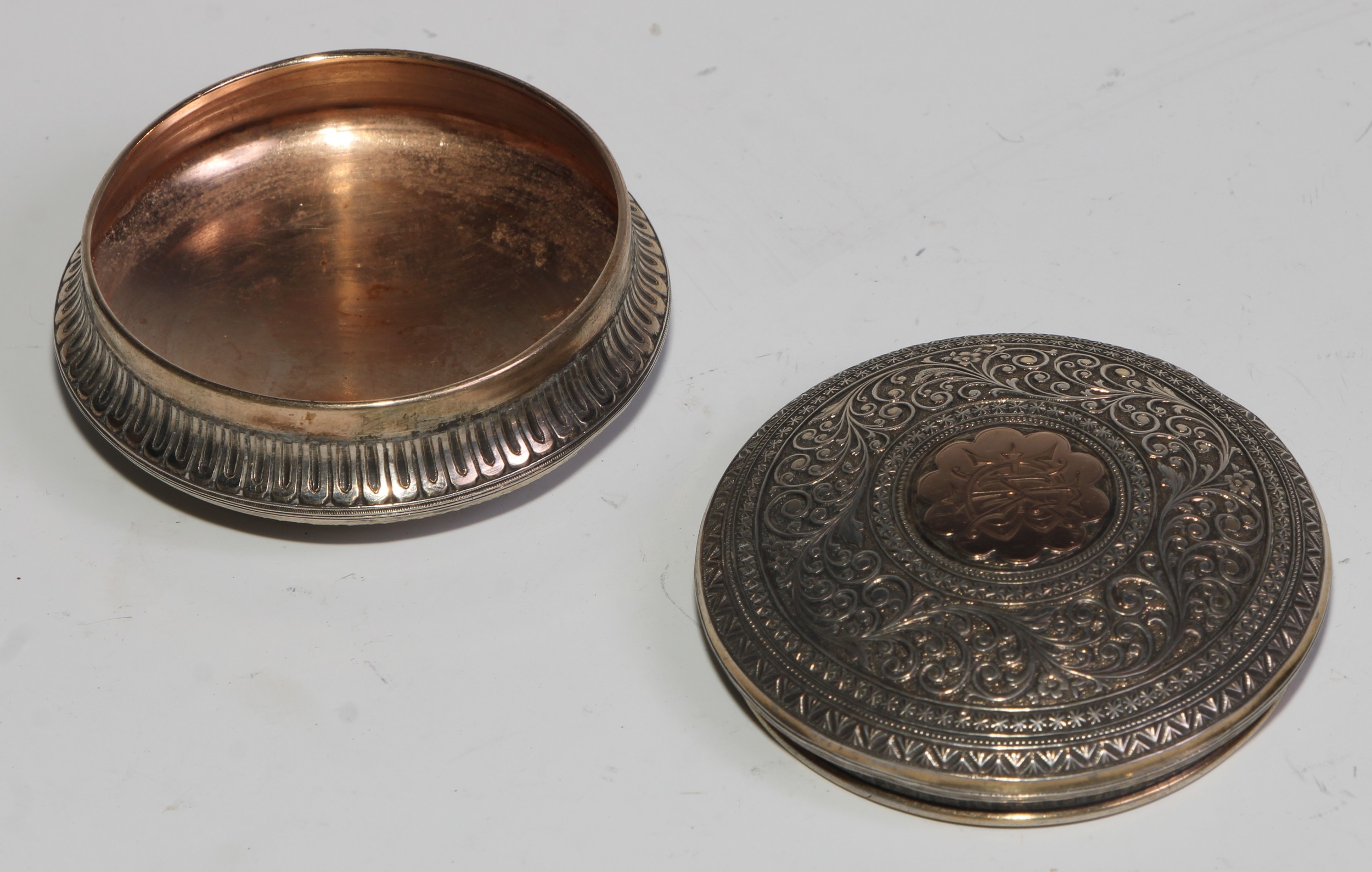 A 19th century silver and gold coloured metal circular snuff box, chased overall in the Indian - Image 4 of 5