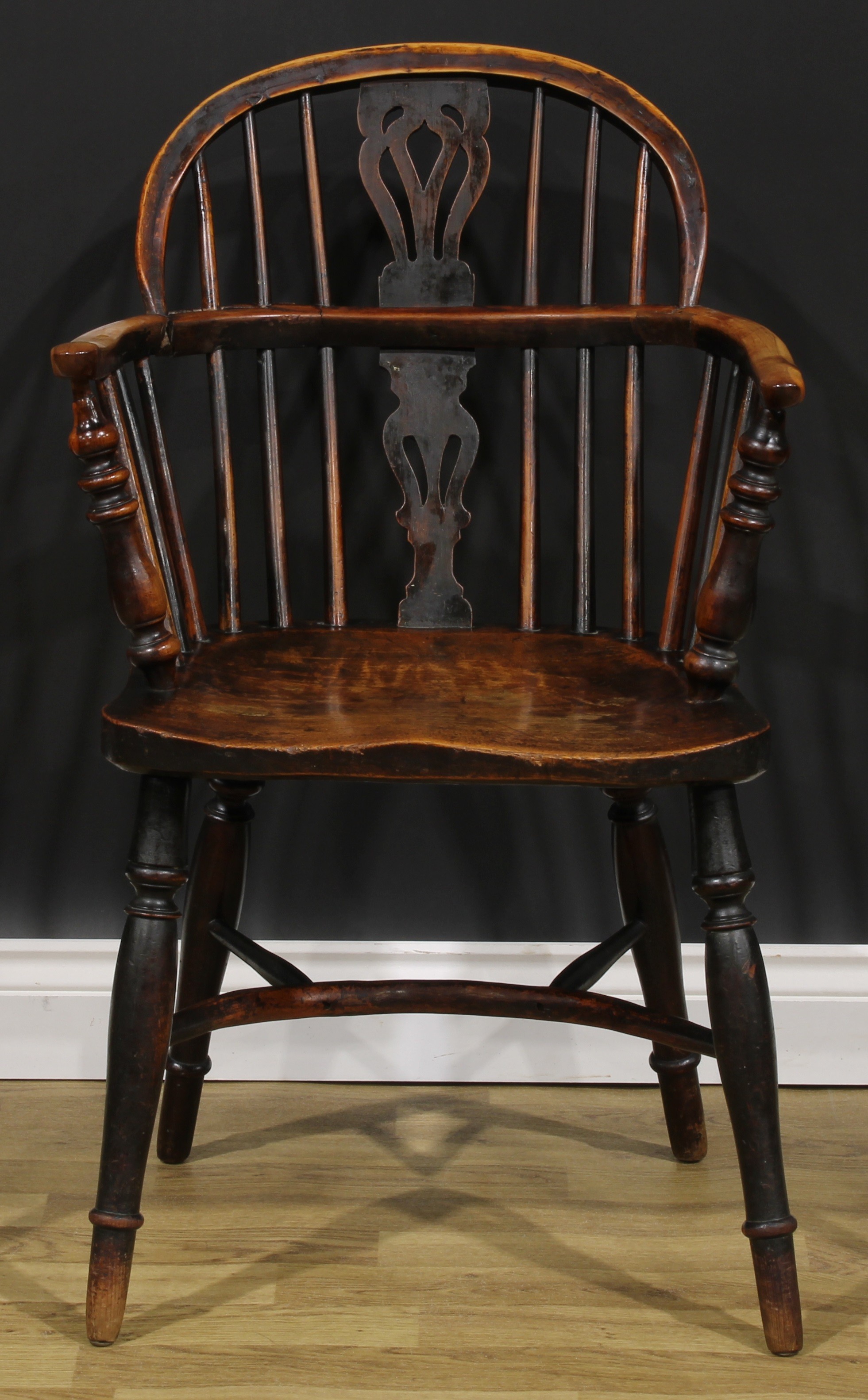 A 19th century East Midlands yew, ash and elm Windsor elbow chair, low hoop back, shaped and pierced