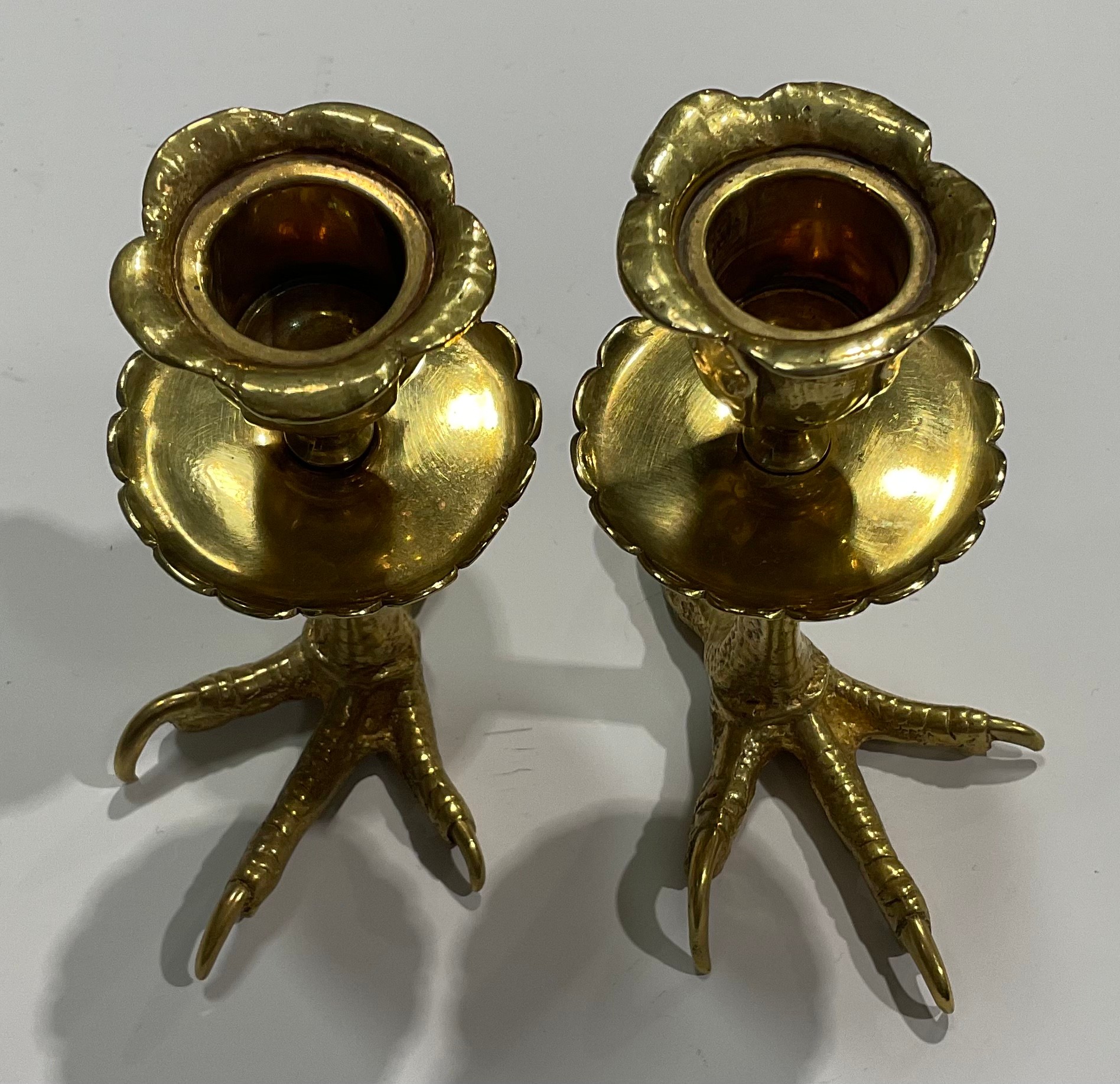 A pair of brass candlesticks, each base cast as an eagles foot, foliate moulded nozzles, shaped - Image 4 of 4