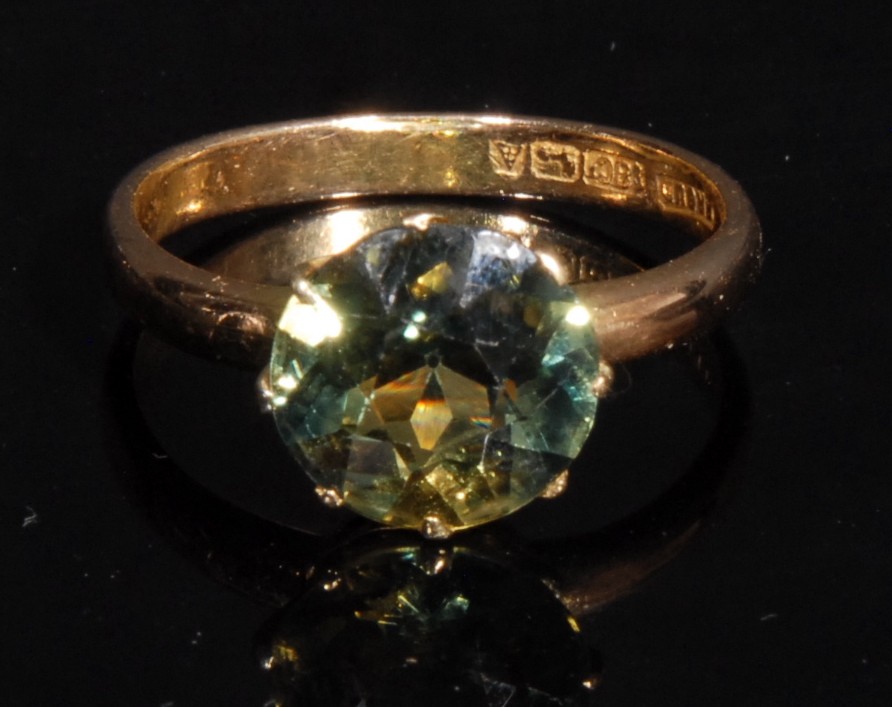 A yellow/green sapphire solitaire ring, round brilliant cut diamond approx 9.9mm diameter, the