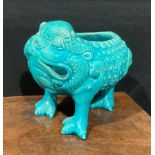 A Burmantofts Faience spoon warmer, as a grotesque three-legged toad, Jin Chan Toad, glazed