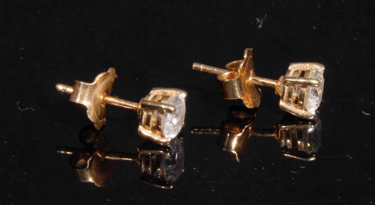A pair of round brilliant cut diamond ear studs, stamped '750' for 18ct gold, each diamond - Image 2 of 2