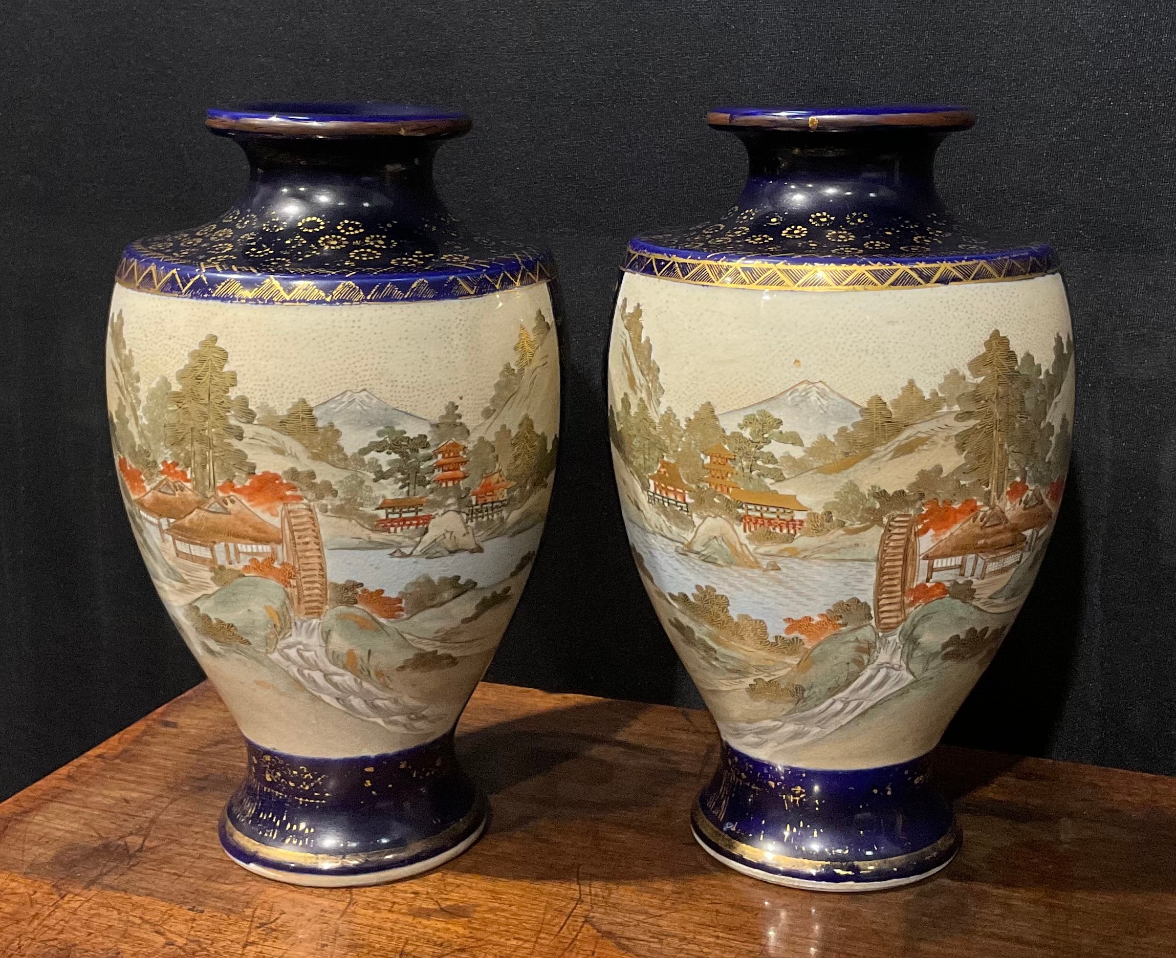 A pair of Japanese satsuma baluster vases, decorated with traditional landscape and bird panels,