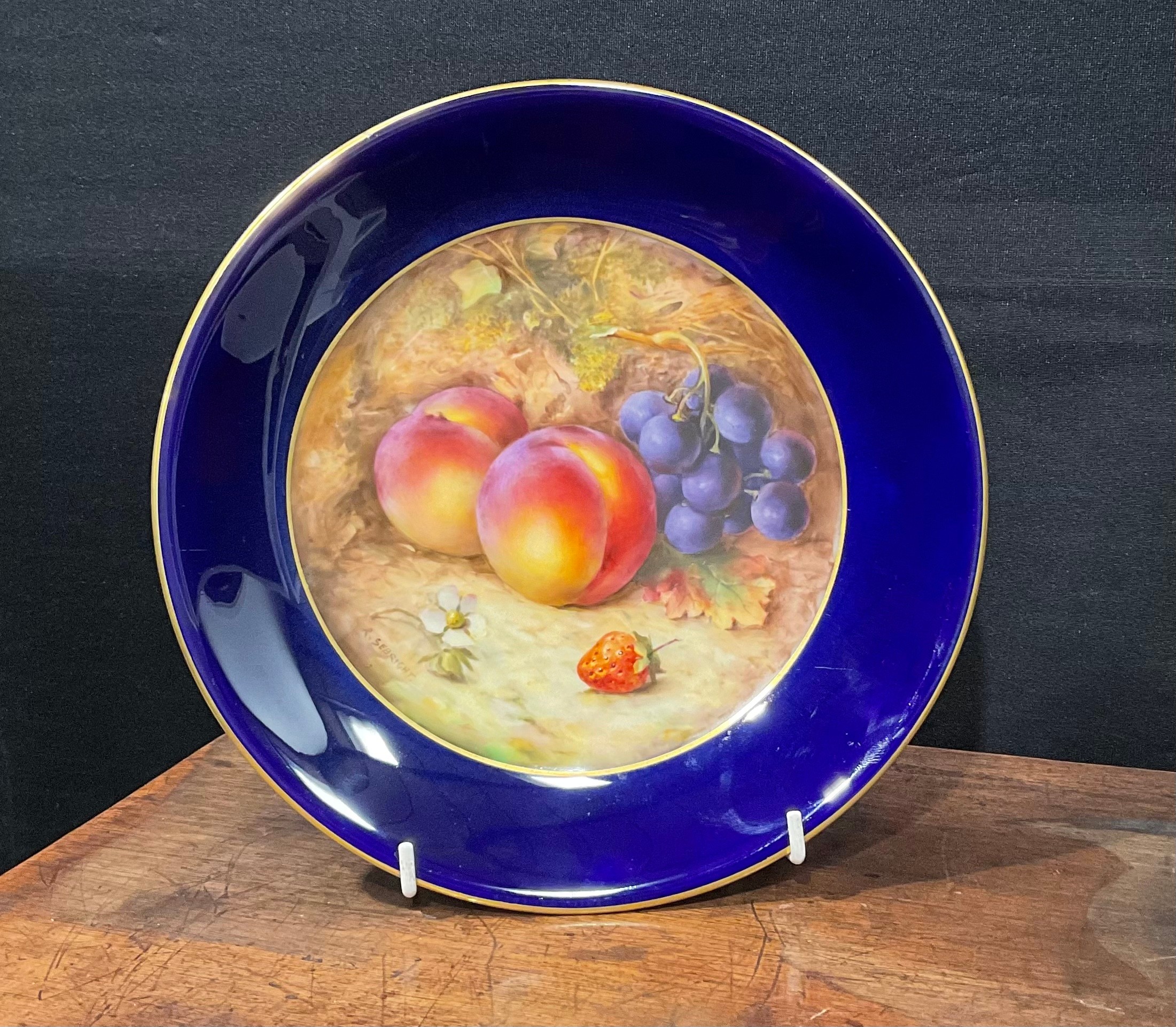 A Royal Worcester circular plate, painted by R. Sebright, signed, the field with peaches, grapes and