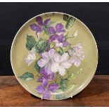 A Howell & James Aesthetic Movement circular charger, painted by F M Minns, with clematis on a green