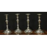 A set of four George II silver table candlesticks, wrythen pillars, piecrust nozzles and bases, 26.