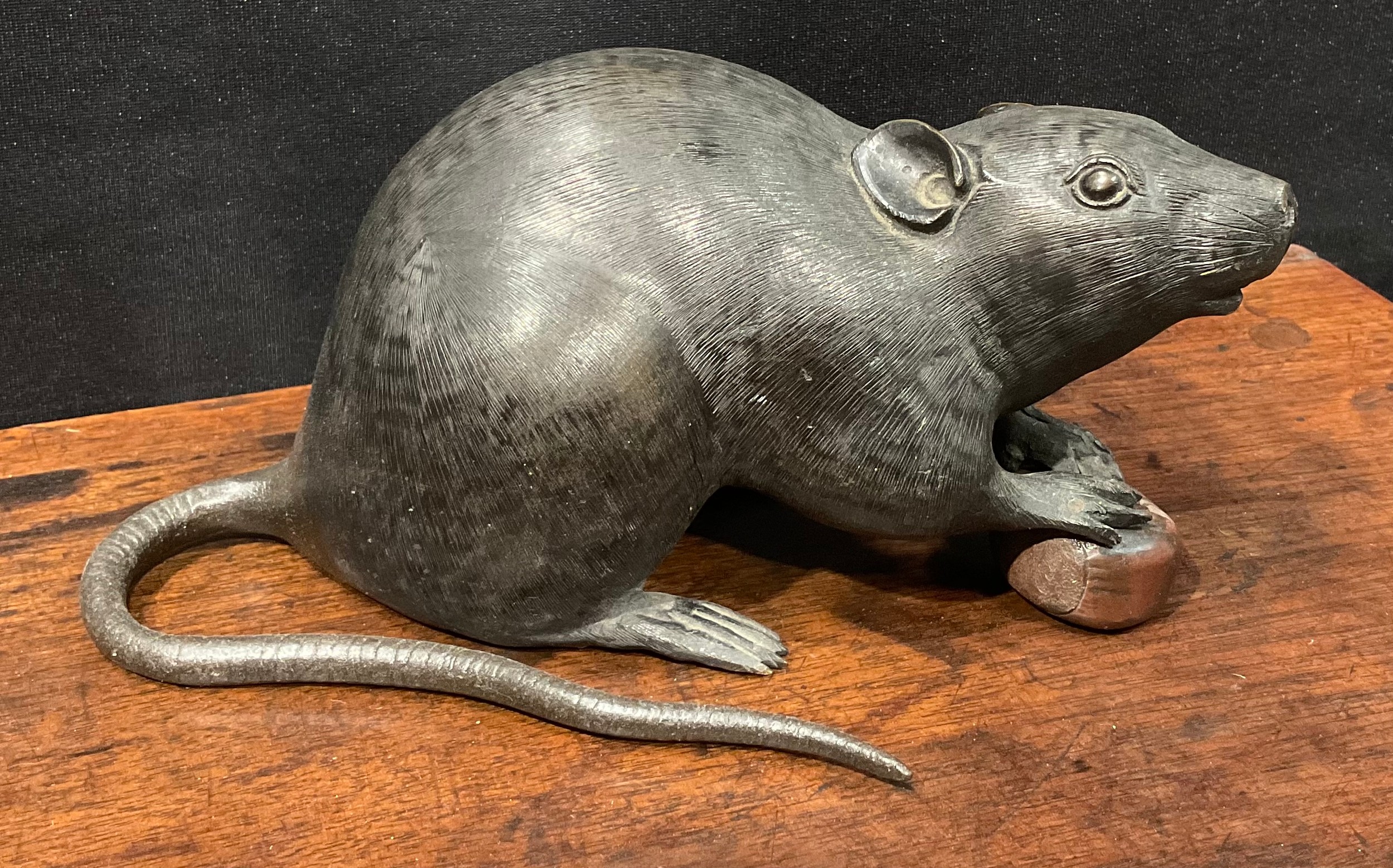 Japanese School (Meiji period), a dark and brown patinated bronze, of a rat holding a chestnut, 19cm