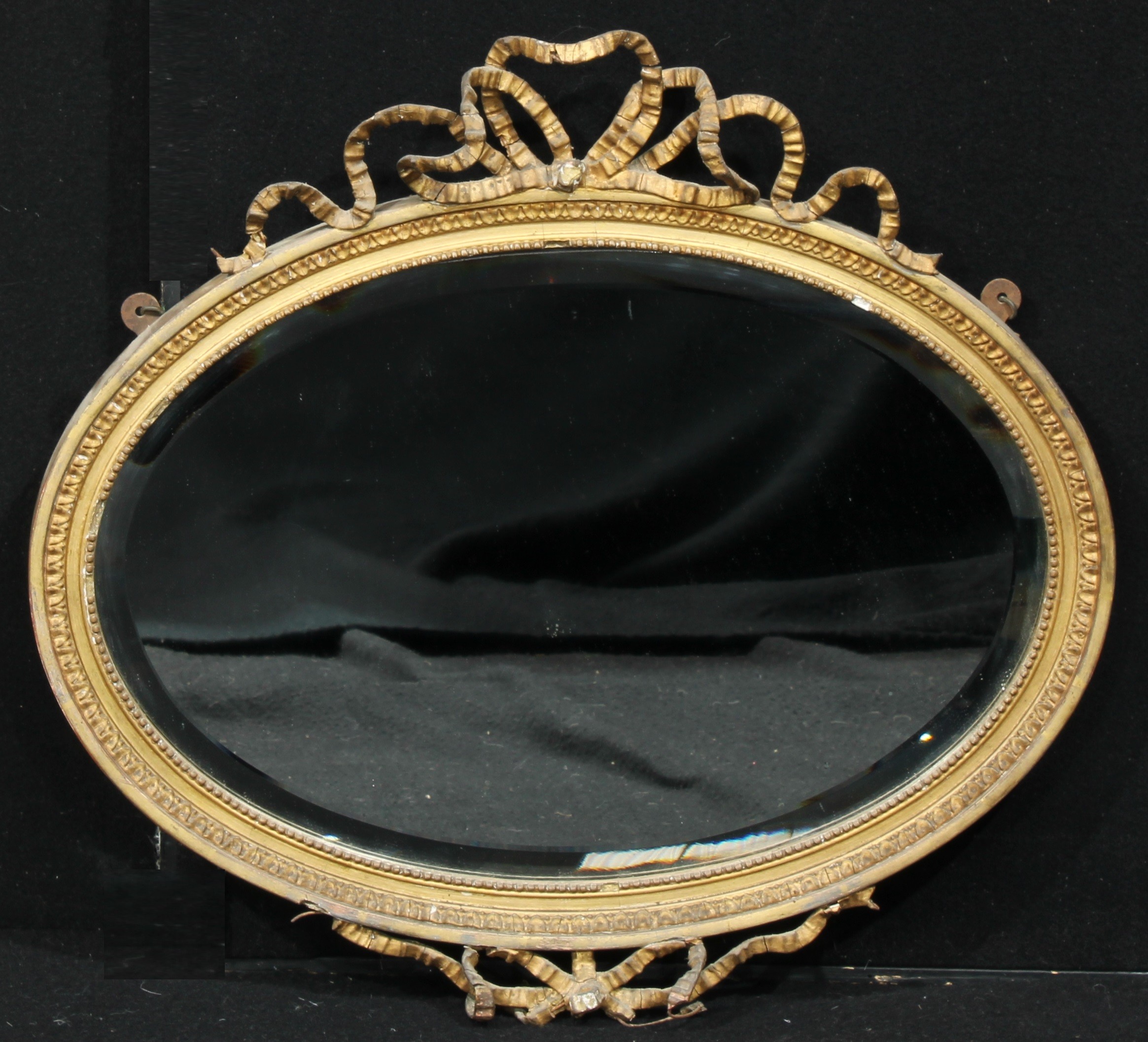 A 19th century oval giltwood and gesso pier glass, bevelled mirror plate, the frame applied with a