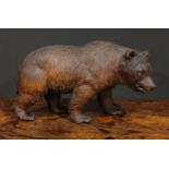 A large Black Forest bear, naturalistically carved, on all fours, glass eyes, painted mouth, 36cm